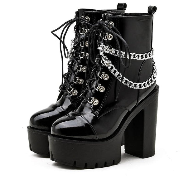 Black patent leather ankle boot with platform heel, laceup, and draped chain accent 